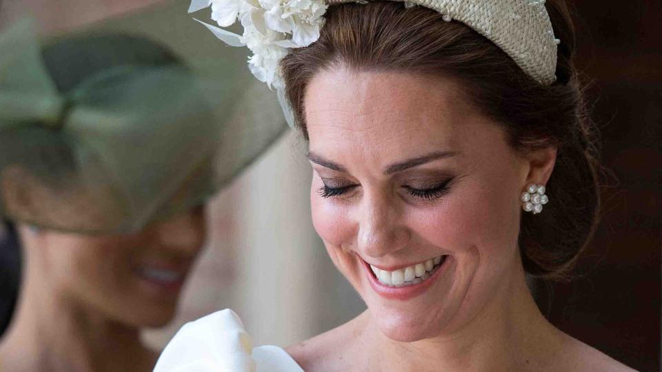 Princess Kate in a headband holding baby prince louis