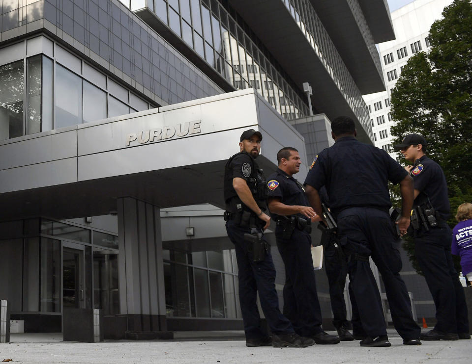 In this Aug. 17, 2018 photo, Stamford Police stand outside the headquarters of Purdue Pharma, which is owned by the Sackler family, in Stamford, Conn. The Sackler family came under scrutiny when a legal filing in Massachusetts gave detailed allegations of how family members and other Purdue Pharma executives sought to push prescriptions for the drug OxyContin and downplay its addiction risks. (AP Photo/Jessica Hill)