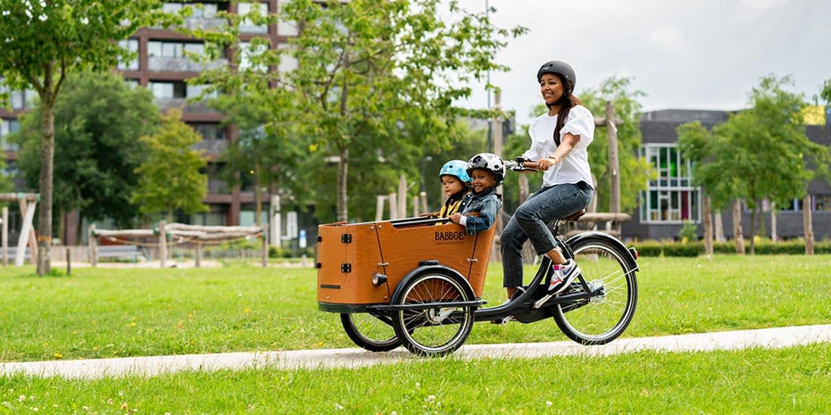 A Babboe bike being ridden by a mother with children (Babboe)