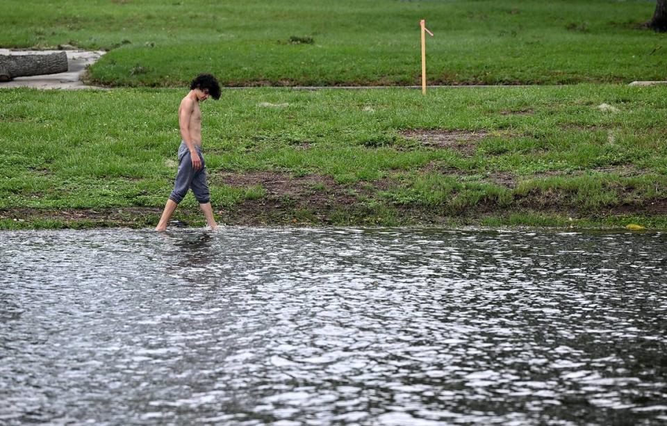 A young man walks through the rising waters of Palma Sola Park after Hurricane Idalia passed on August 30, 2023.