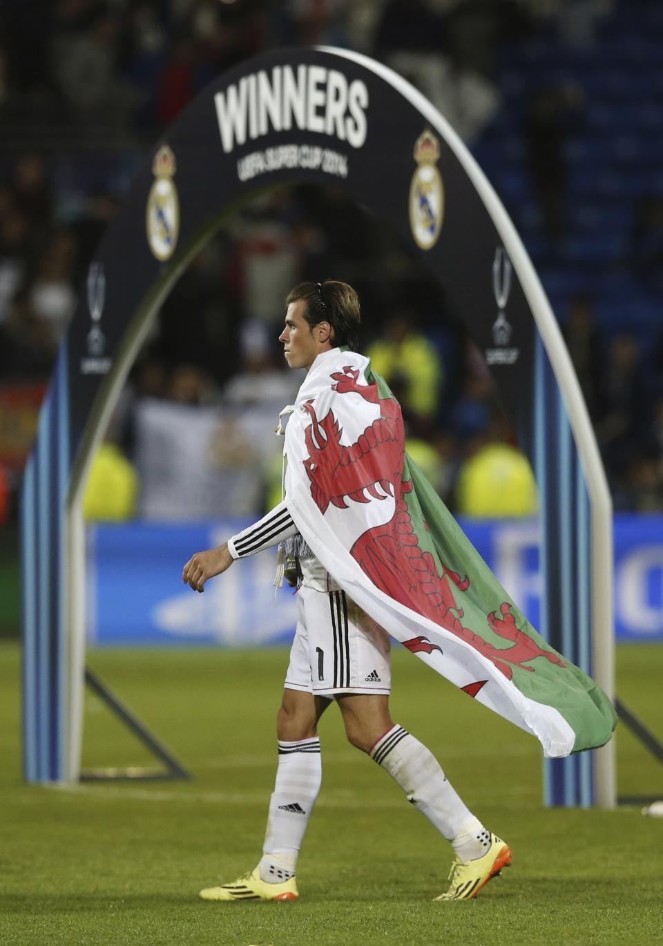 FILE - Real Madrid's Gareth Bale walks with the trophy after winning the UEFA Super Cup soccer match between Real Madrid and Sevilla in Cardiff City Stadium, in Cardiff, Wales, Tuesday, Aug. 12, 2014. (AP Photo/Alastair Grant, File)