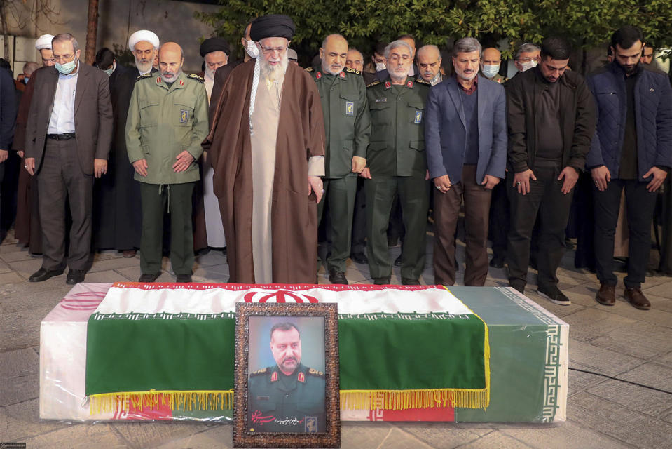 In this photo released by an official website of the office of the Iranian supreme leader, Supreme Leader Ayatollah Ali Khamenei, front, prays over the flag-draped coffin of Seyed Razi Mousavi, a high ranking Iranian general of the paramilitary Revolutionary Guard, who was killed in an alleged Israeli airstrike in Syria on Monday, in Tehran, Iran, Thursday, Dec. 28, 2023. (Office of the Iranian Supreme Leader via AP)