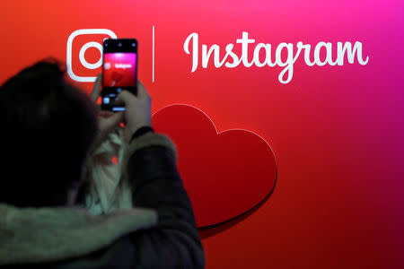 FILE PHOTO: A visitor takes a picture of the Instagram application logo at the Young Entrepreneurs fair in Paris, France, February 7, 2018. REUTERS/Charles Platiau/File Photo