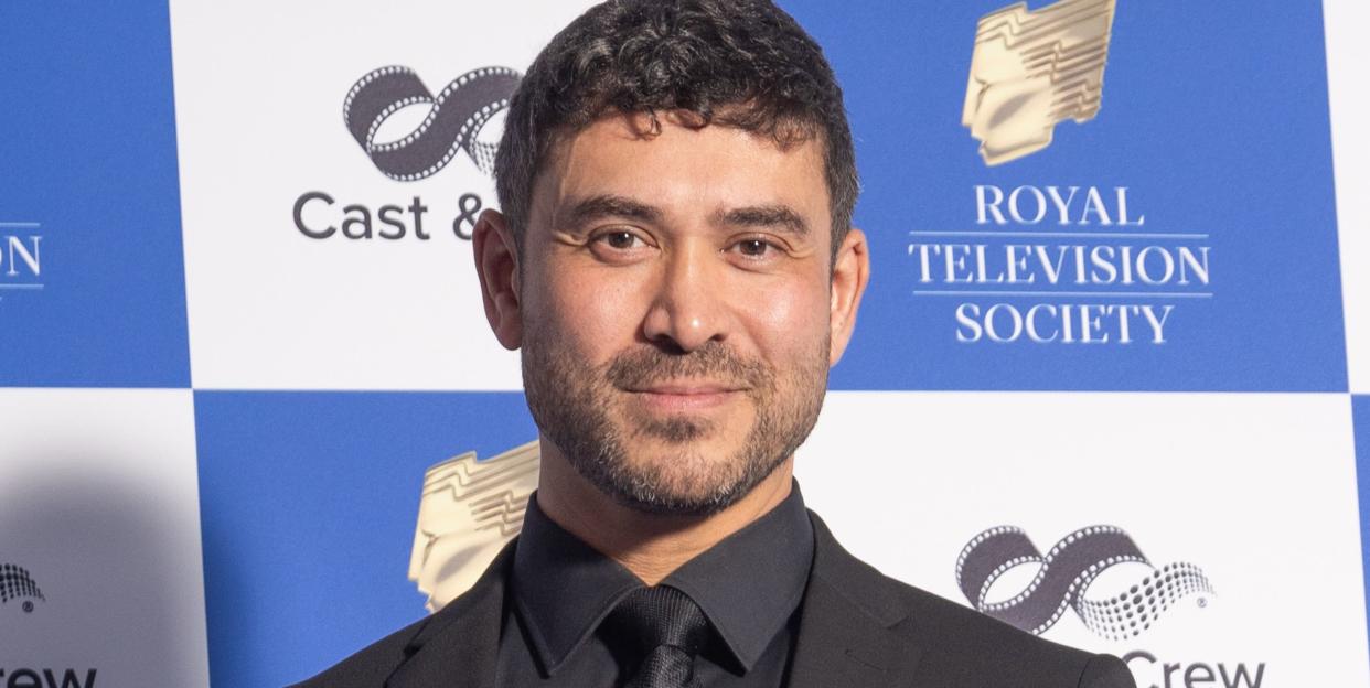 rav wilding on a red carpet in a very sharp black suit