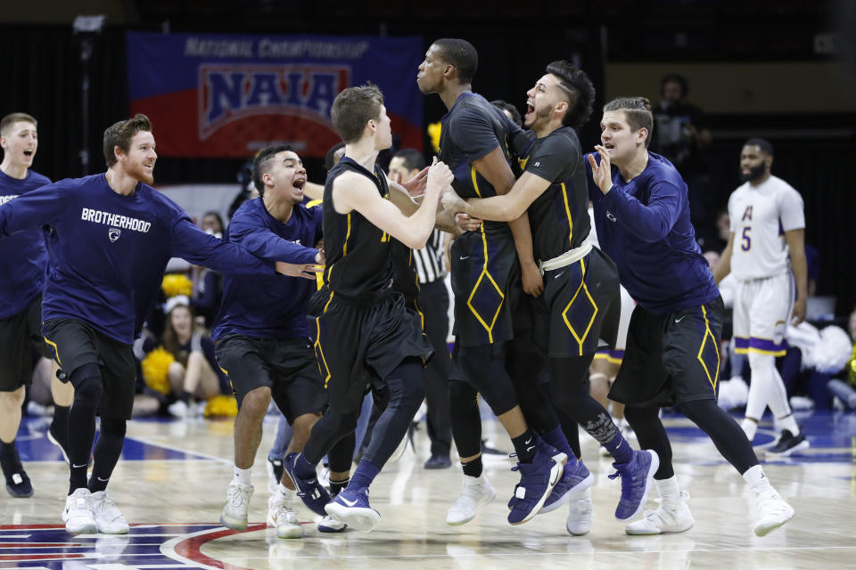 Graceland’s Justin Harley, center, celebrates his game-winning overtime basket with Dalton Payton, left, Waseem Limbada, right, and other teammates in the NAIA men’s championship college basketball game Tuesday, March 20, 2018, in Kansas City, Mo. Graceland defeated LSU Alexandria 83-80. (AP Photo/Colin E. Braley)