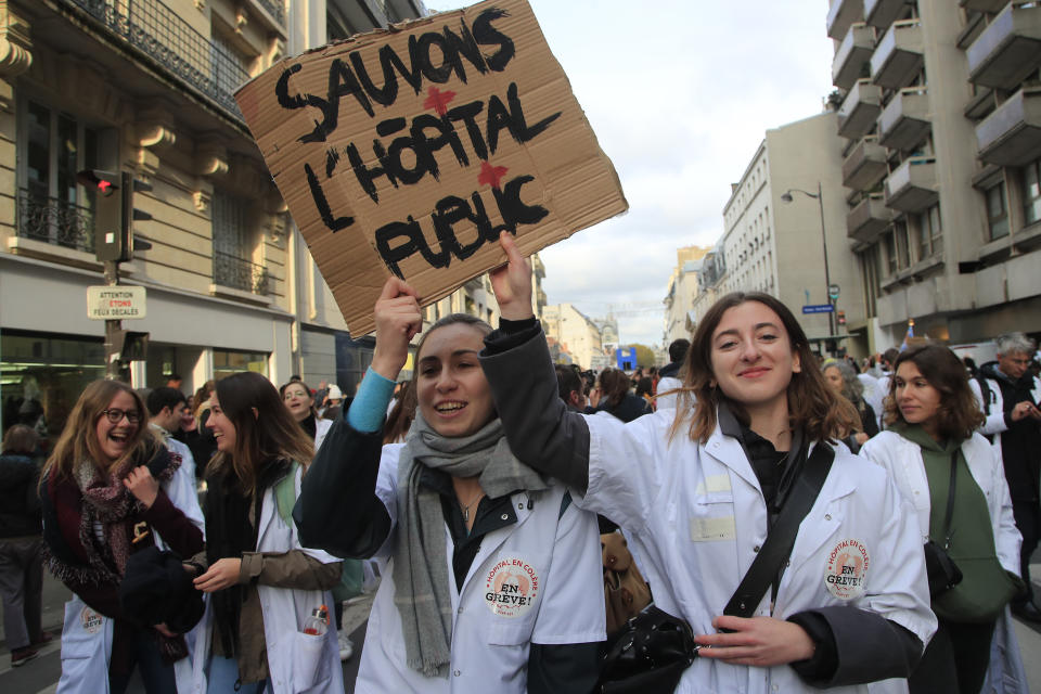 Medical staffs hold a poster reading "Save Public Hospitals" during a national demonstration Thursday, Nov. 14, 2019 in Paris. Thousands of exasperated nurses, doctors and other public hospital workers are marching through Paris to demand more staff and resources after years of cost cuts. (AP Photo/Michel Euler)