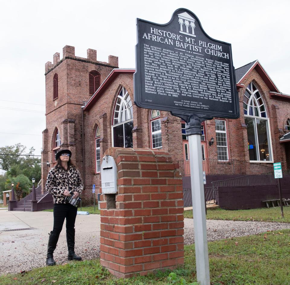 Cassandra Sharpe reads the historical marker outside the Mt. Pilgram African Baptist Church in Milton on Wednesday, Nov. 15, 2023. Milton recently voted to amend its Unified Development Code to allow for buildings and other sites outside its existing National Historic District to be classified as local historic resources. The move creates a voluntary program to allow owners of historically significant homes and buildings to obtain some of the protections and benefits homes, buildings, and other sites within the district now enjoy.