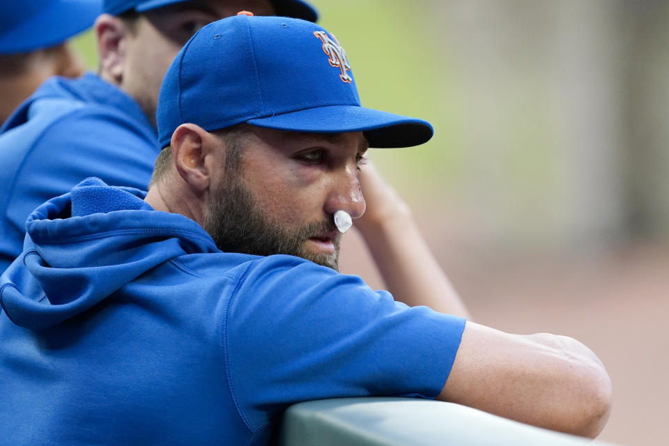 New York Mets' Kevin Pillar watches from dugout before the team's baseball game against the Atlanta Braves on Tuesday, May 18, 2021, in Atlanta. Pillar was hit on the face with a Jacob Webb fastball the night before. (AP Photo/John Bazemore)