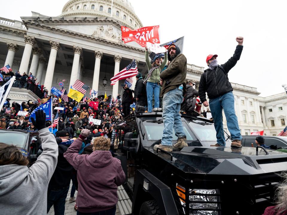 Trump supporters stand on the US Capitol Police armored vehicle