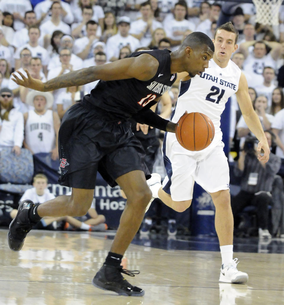 San Diego State's Winston Shepard (13) brings the ball down the court as Utah State guard/forward Spencer Butterfield (21) defends in the first half of an NCAA college basketball game Saturday, Jan. 25, 2014, in Logan, Utah. (AP Photo/Eli Lucero)