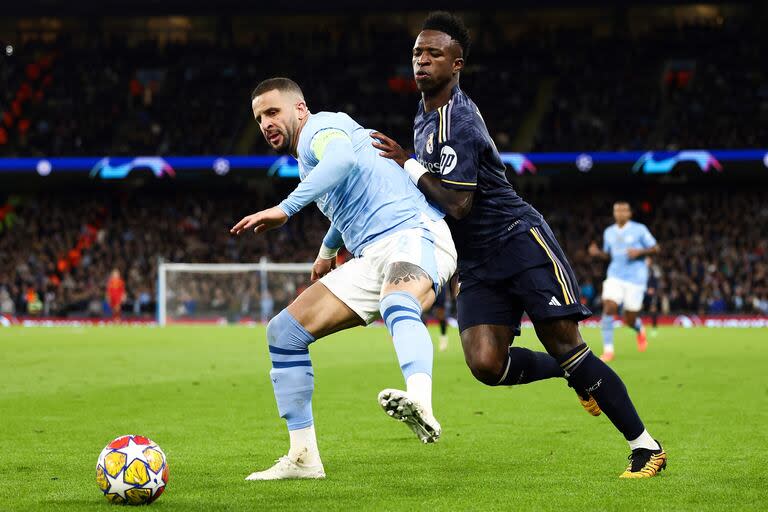 Manchester City's English defender #02 Kyle Walker (L) fights for the ball with Real Madrid's Brazilian forward #07 Vinicius Junior during the UEFA Champions League quarter-final second-leg football match between Manchester City and Real Madrid, at the Etihad Stadium, in Manchester, north-west England, on April 17, 2024. (Photo by Darren Staples / AFP)