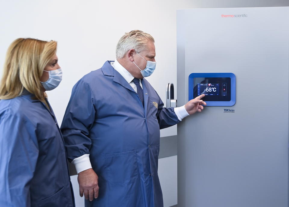 Ontario Premier Doug Ford, right, and Ontario Health Minister Christine Elliott look at freezers ahead of COVID-19 vaccine distribution in Toronto, Tuesday, Dec. 8, 2020. (Nathan Denette/The Canadian Press via AP)