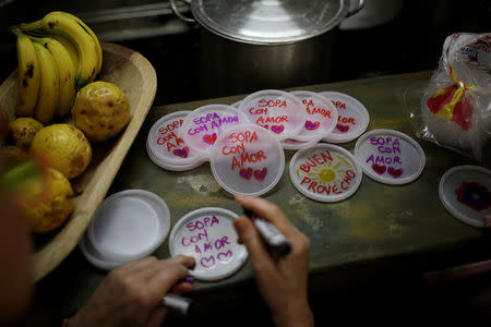 Lids with messages that read "soup with love" are seen at the home kitchen of a volunteer of Make The Difference (Haz La Diferencia) charity initiative, in Caracas, Venezuela March 5, 2017. REUTERS/Marco Bello