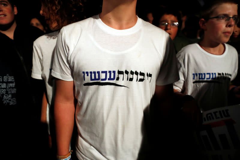 An Israeli youth wears a t-shirt with Hebrew writing reading, "Sovereignty Now" as he takes part in a protest calling on Israeli Prime Minister Benjamin Netanyahu to declare sovereignty over Israel's settlements in the occupied West Bank, in Jerusalem