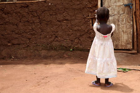 A three-year-old girl who was offered for international adoption without her family's knowledge walks at her grandmother's home in rural Uganda, April 14, 2015. REUTERS/Katy Migiro