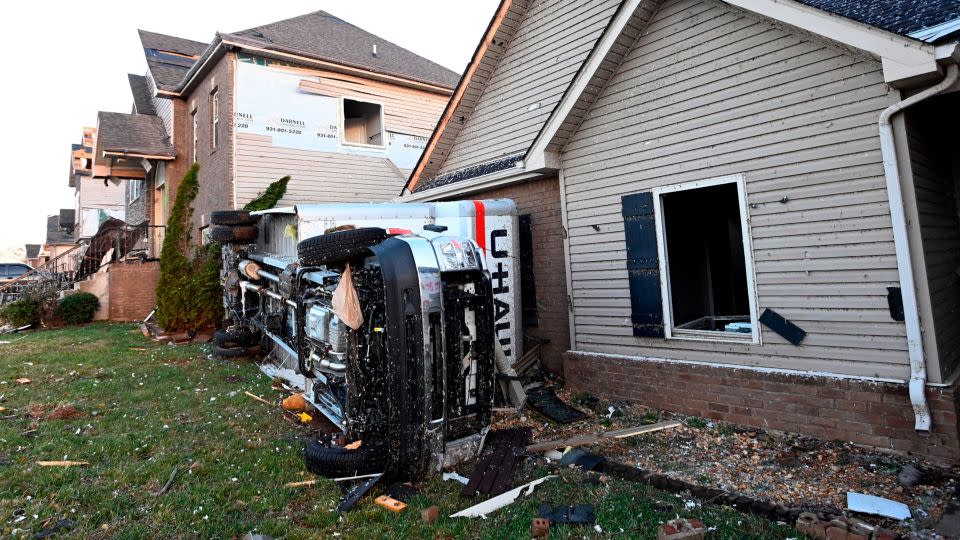 A truck lies on its side beside damaged homes on Sunday, Dec. 10, 2023, Clarksville, Tennessee, where residents and emergency workers are continuing the cleanup from severe weekend storms. - Mark Zaleski/AP