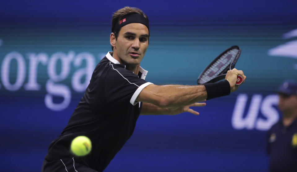 FILE - In this Sept. 3, 2019, file photo, Roger Federer, of Switzerland, chases a shot from Grigor Dimitrov, of Bulgaria, during the quarterfinals of the U.S. Open tennis tournament in New York. The Swiss government said it will produce a 20 franc silver coin with Federer’s image on it. It is the first time Switzerland has dedicated a commemorative coin to a living person. (AP Photo/Charles Krupa, File)