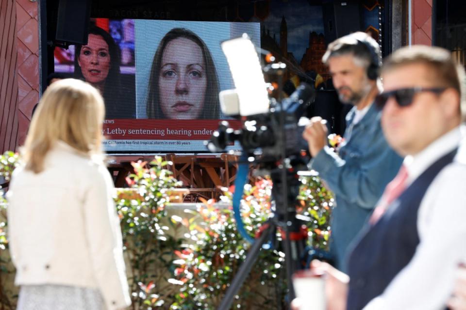 Members of the media work near a large screen showing a picture of convicted hospital nurse Lucy Letby, ahead of her sentencing, outside the Manchester Crown Court (REUTERS)