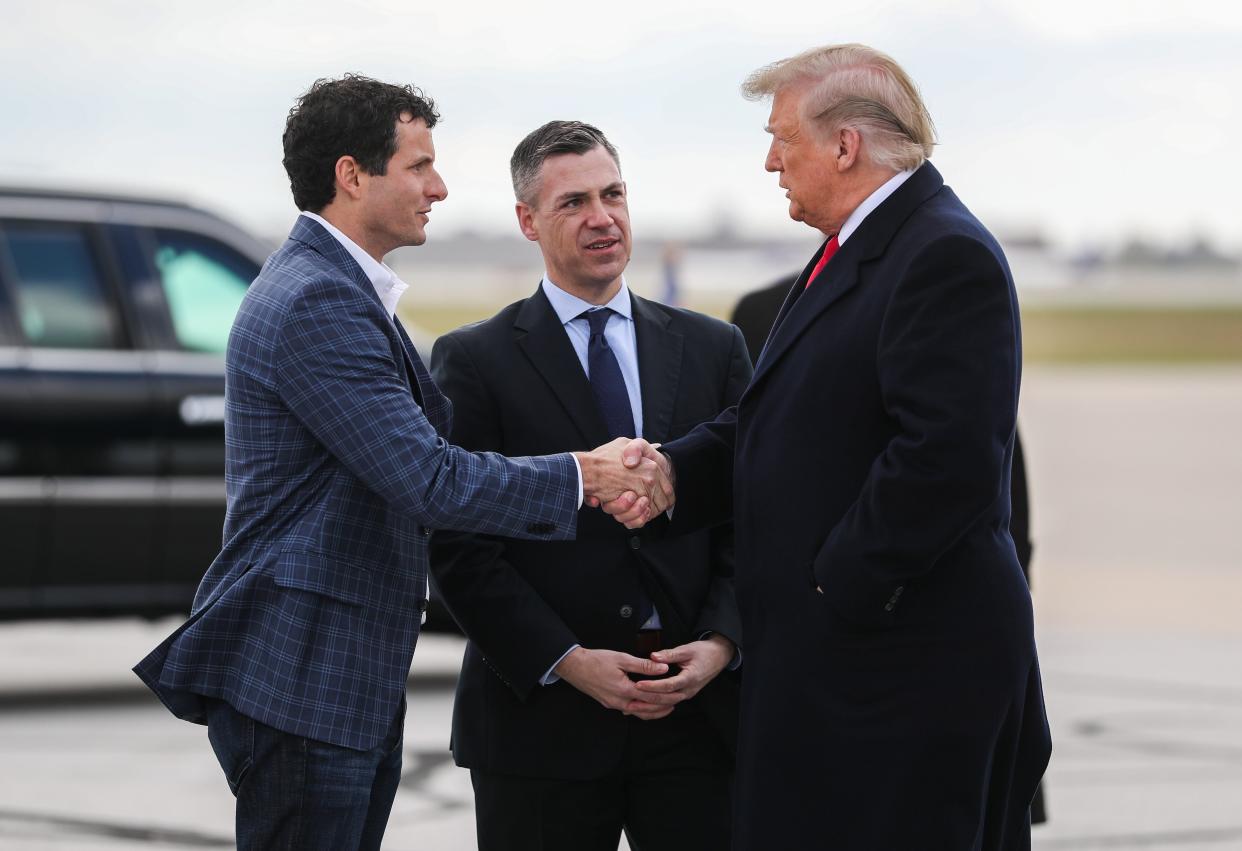 President Donald Trump greets, from left, Trey Hollingsworth and Rep. Jim Banks at the Indianapolis International Airport on his way to speak to attendees at the FFA convention in Downtown Indianapolis, Saturday, Oct. 27, 2018.