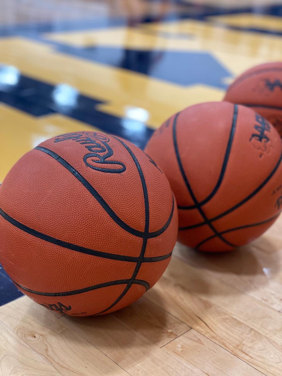 Basketballs sit on the court.