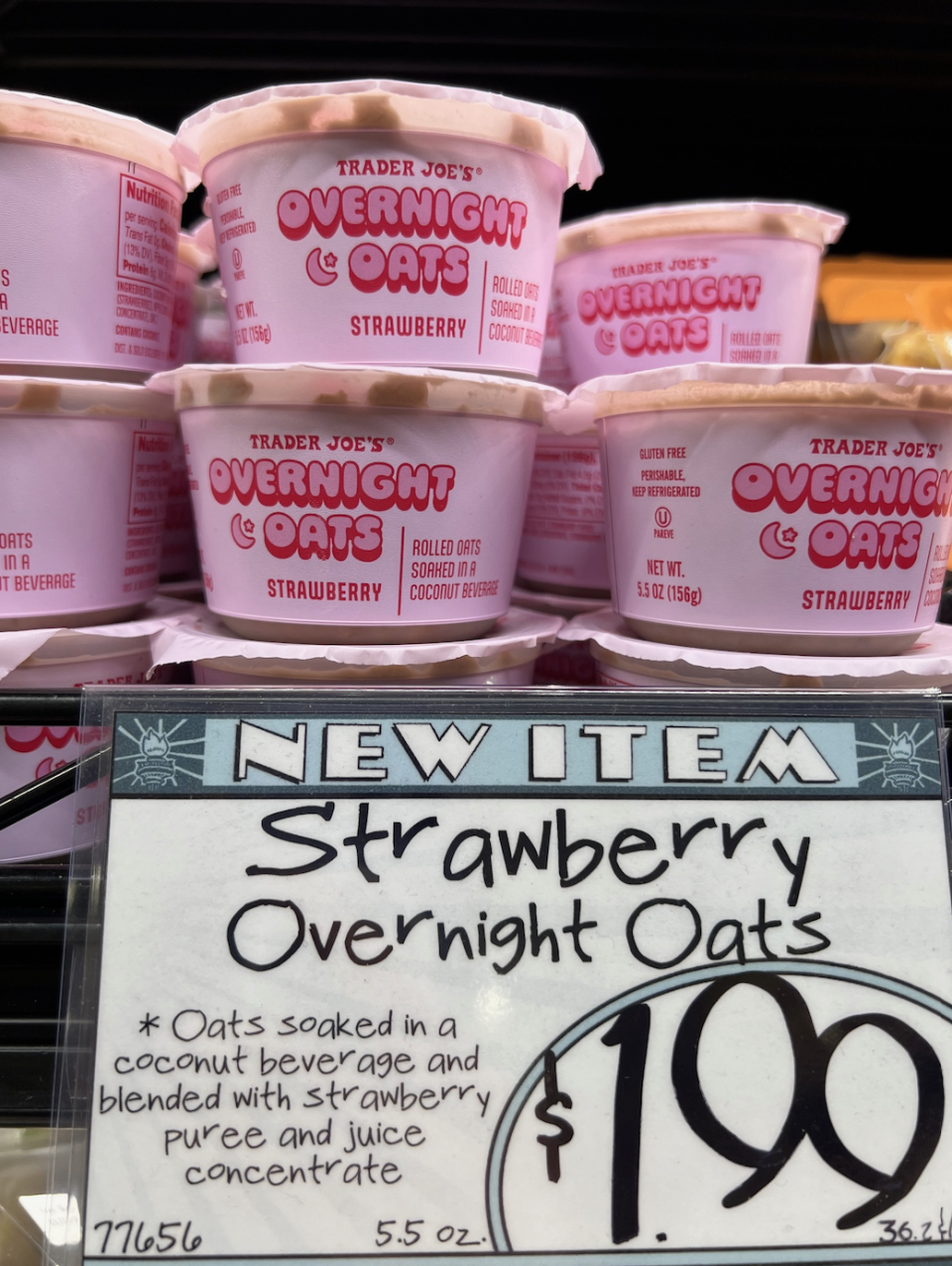 Shelves stocked with containers of Trader Joe's new Strawberry Overnight Oats, with a price tag of $1.99 in the foreground