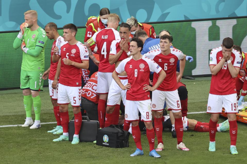 Denmark's players react as their teammate Christian Eriksen lays on the ground during the Euro 2020 soccer championship group B match between Denmark and Finland at Parken stadium in Copenhagen, Denmark, Saturday, June 12, 2021. (Wolfgang Rattay/Pool via AP)