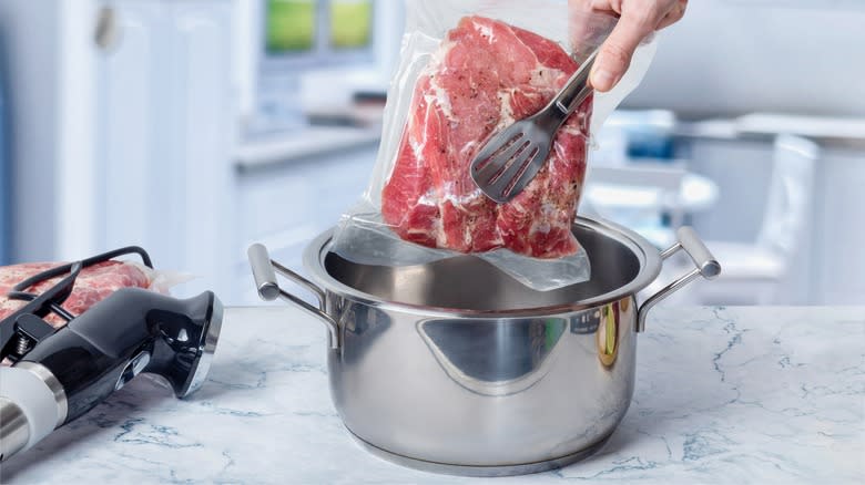 Placing a vacuum sealed joint in a pot ready for sous vide