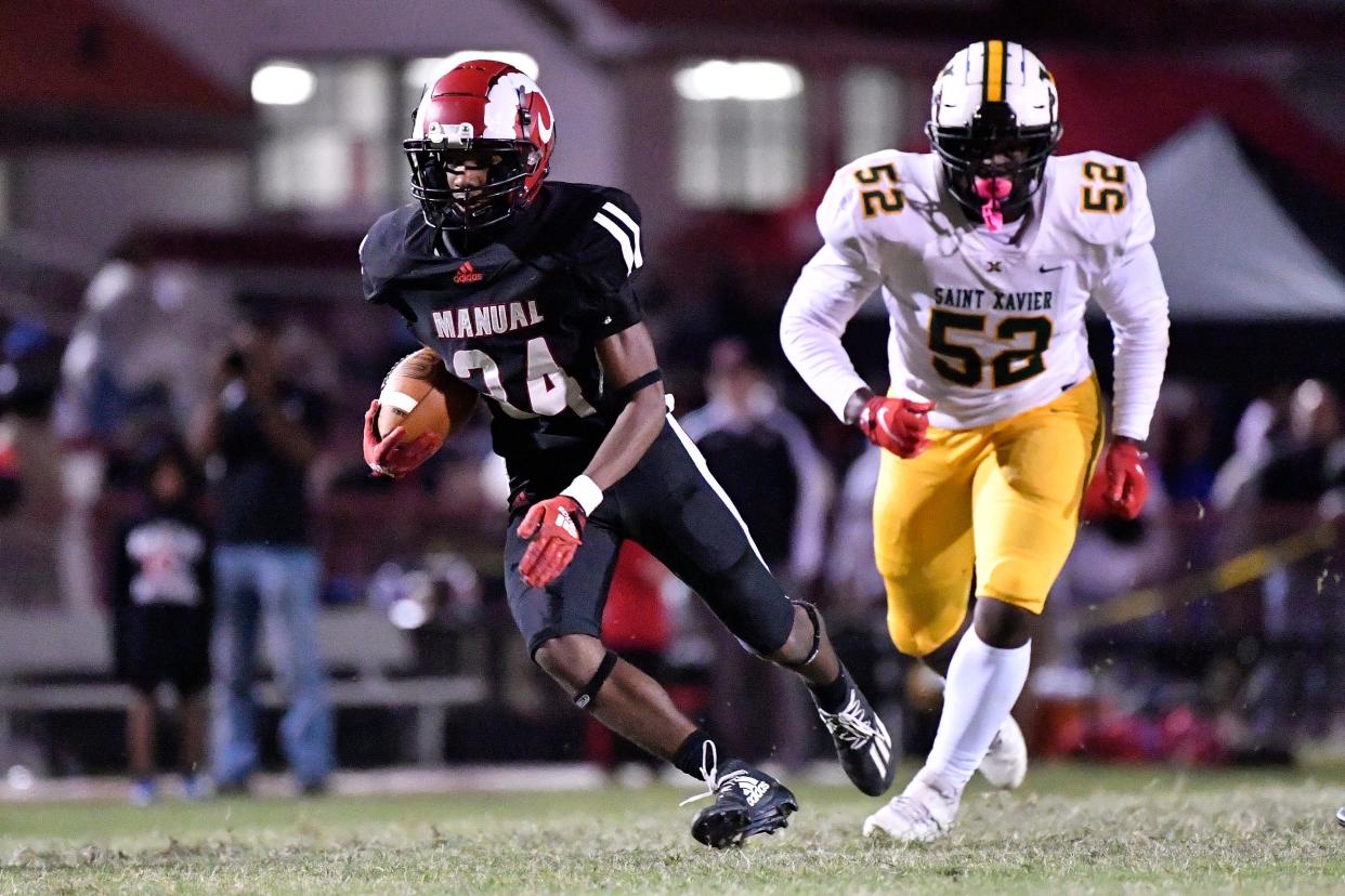 Manual's Gerian Traynor (34) runs through an opening in the St. Xavier line during the second half of their game, Friday, Oct. 6, 2023 in Louisville, Ky. Manual won 37-36.