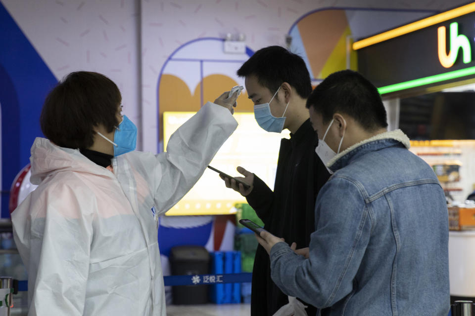 Residents get their temperature checked in Wuhan in central China's Wuhan province on Wednesday, April 1, 2020. Skepticism about China’s reported coronavirus cases and deaths has swirled throughout the crisis, fueled by official efforts to quash bad news in the early days and a general distrust of the government. In any country, getting a complete picture of the infections amid the fog of war is virtually impossible. (AP Photo/Ng Han Guan)