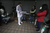 A health worker talks to relatives of COVID-19 patients who have been discharged after recovering from the disease at the Mexico City Ajusco Medio General Hospital, Wednesday, Dec. 2. 2020. Mexico continues to report an increase in the number of coronavirus cases, with Mexico City continuing to report the biggest portion of the surge. (AP Photo/Marco Ugarte)