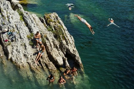 A boy jumps into the Cijevna river to cool off near Tuzi as a heatwave hits Montenegro, August 4, 2017. REUTERS/Stevo Vasiljevic