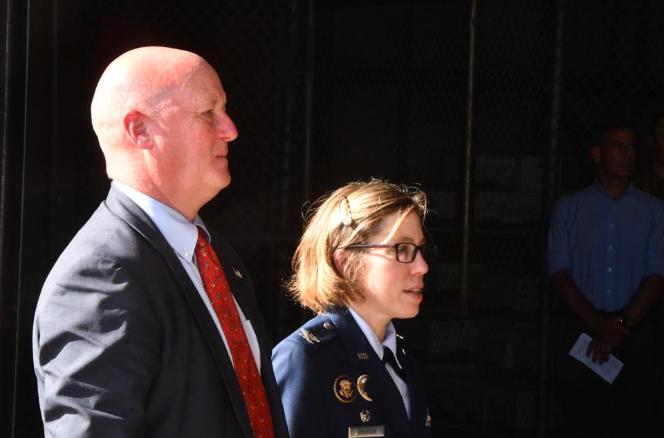 Christopher Thayer, director of maritime operations with Military Sealift Command and Col. Katharine Branson, commander of the Air Force Technical Applications Center, listen during the USNS Invincible inactivation ceremony.