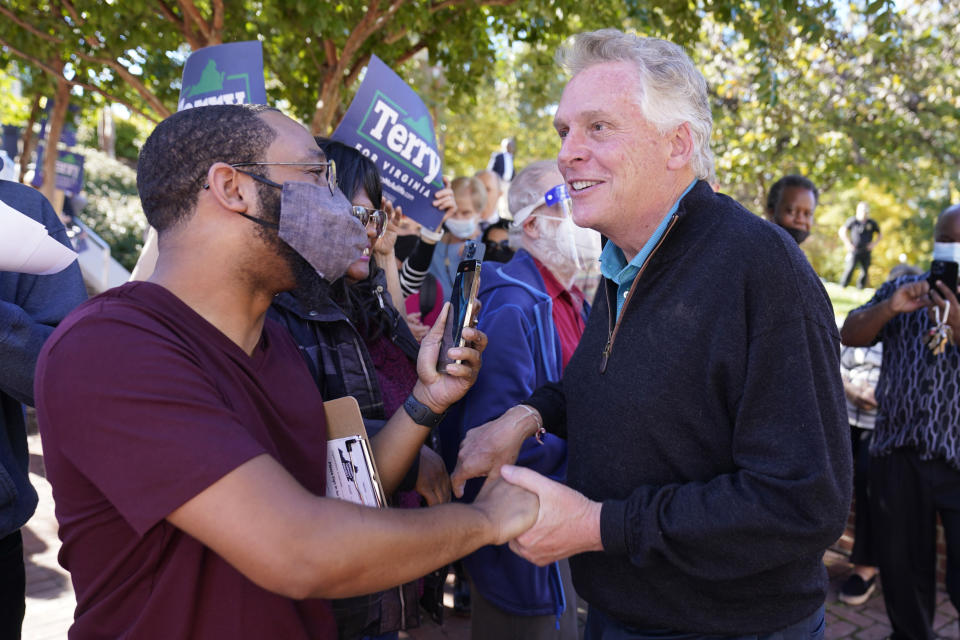 Democratic gubernatorial candidate former Gov. Terry McAuliffe, right, greets supporters during a rally in Lynchburg, Va., Wednesday, Oct. 27, 2021. McAuliffe will face Republican Glenn Youngkin in the November election. (AP Photo/Steve Helber)