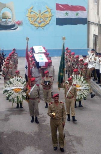 A photo released by the state-run Syrian Arab News Agency (SANA) shows Syrian government troops carrying the coffin of a comrade killed in the ongoing fighting across the country