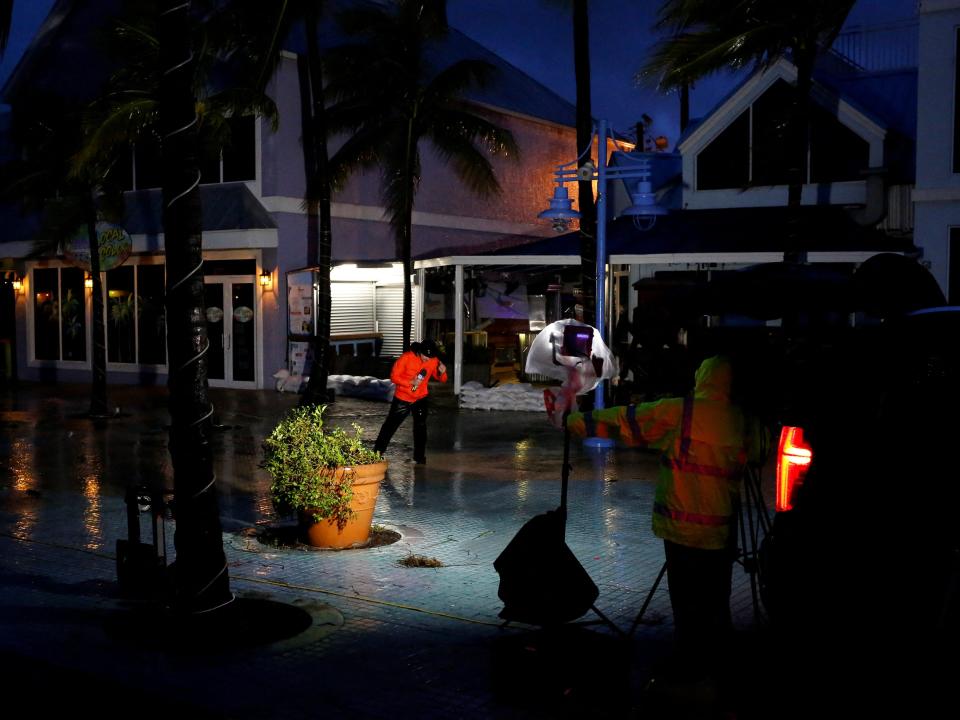 tv crew broadcasts in the dark rainy hurricane ian