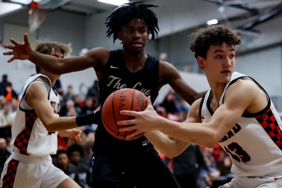 Looking to pass is Hiland's Sam Wengerd with some tough defense from Lutheran East.