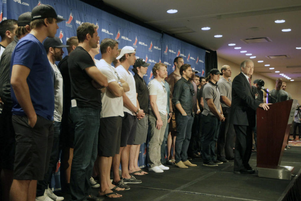 FILE - In this Sept. 13, 2012, file photo, National Hockey League Players' Association executive director Donald Fehr, right, is joined by hockey players as he speaks to reporters during a news conference in New York. The NHLPA announces its decision whether to terminate the current collective bargaining agreement and set the clock ticking toward another potential work stoppage in 2020. (AP Photo/Mary Altaffer, File)