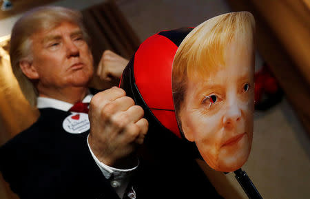 A performer with a mask of U.S. President Donald Trump hits a punching ball with a mask of German Chancellor Angela Merkel in the Madame Tussauds wax museum in Berlin, Germany, August 14, 2018. REUTERS/Hannibal Hanschke