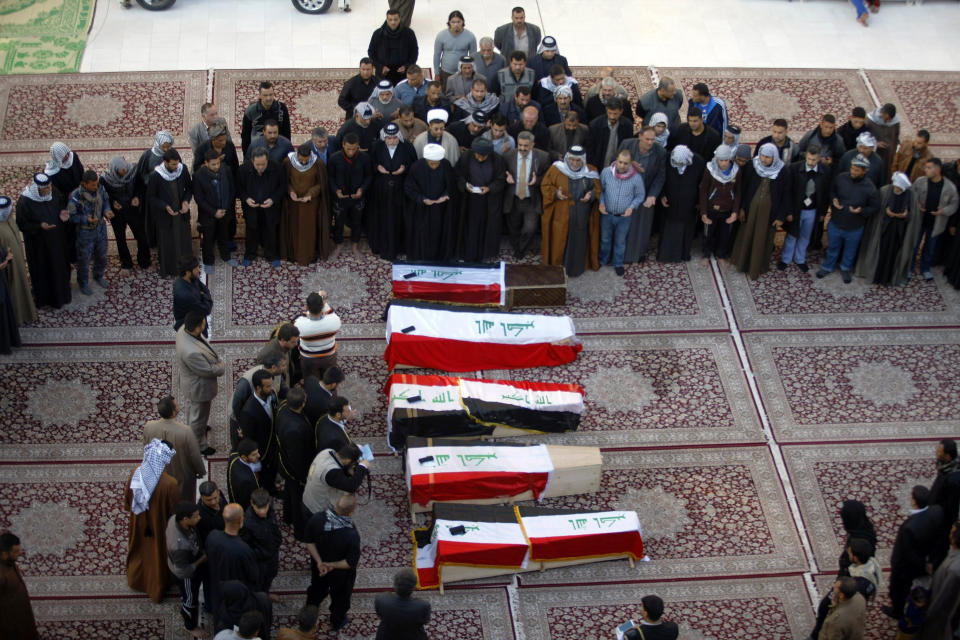 FILE - In this file photo taken Tuesday, Jan. 21, 2014, mourners pray over five coffins draped with Iraqi flags for Iraqi soldiers killed by al-Qaida militants in Anbar province during their funeral procession inside the shrine of Imam Ali in Najaf, Iraq. More than a month after jihadist militants seized control of parts of Iraq’s western Anbar province, an unsettling realization is sinking in: Iraq’s government could face a tougher time beating back an insurgency there than the hard slog the Americans faced last decade. The reasons include a deep distrust of the government by Iraqi Sunnis, insufficient resources, sectarian tensions enflamed by the war in Syria and divisions among the tribes that make up Anbar’s social fabric. (AP Photo/Jaber al-Helo, File)