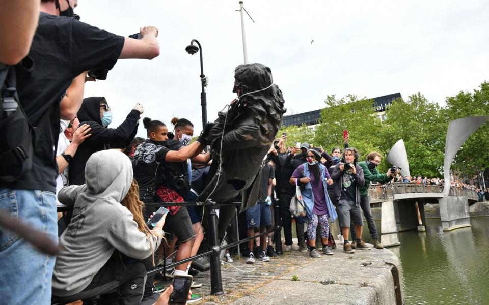 Protesters throw a statue of Edward Colston into Bristol harbour during a Black Lives Matter protest rally - PA