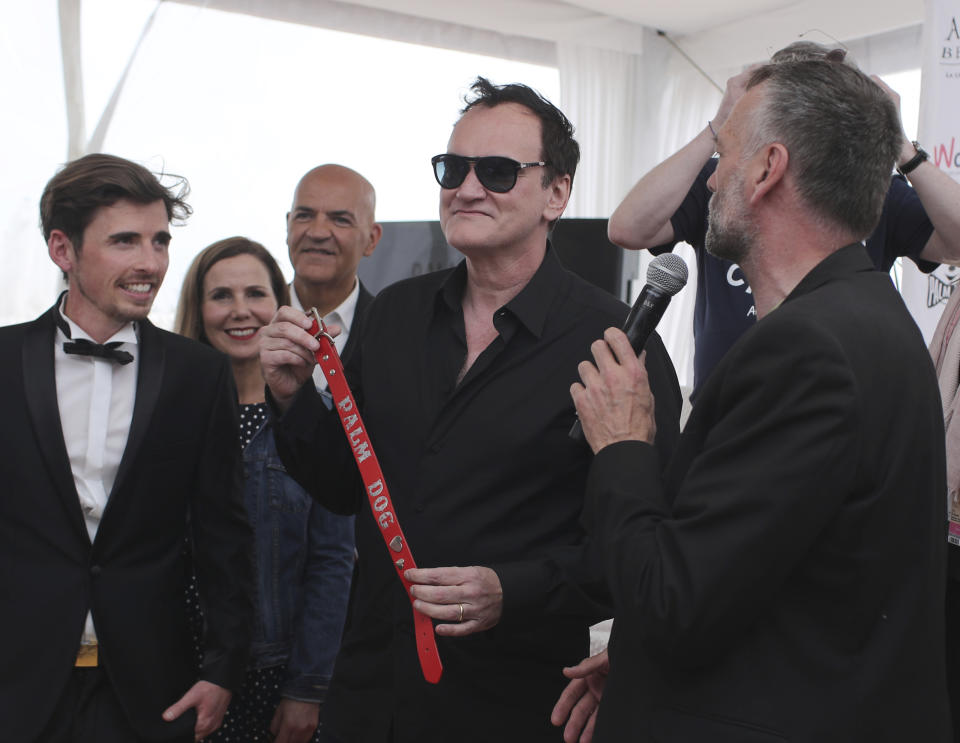 Director Quentin Tarantino poses for photographers with the Palm Dog collar award for the the dog Brandy that appeared in his film 'Once Upon a Time in Hollywood' at the 72nd international film festival, Cannes, southern France, Friday, May 24, 2019. (AP Photo/Petros Giannakouris)