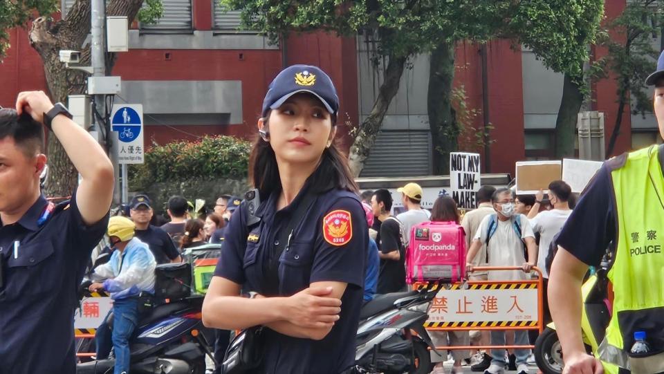 <strong>正妹女警雙手抱胸、全神貫注盯著活動現場警戒。（圖／翻攝畫面）</strong>