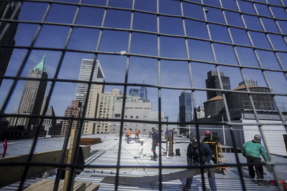 Construction workers update the roofing on a high rise at 160 Water Street in Manhattan's financial district, for the building's conversion to residential apartments, Tuesday, April 11, 2023, in New York. (AP Photo/Bebeto Matthews)