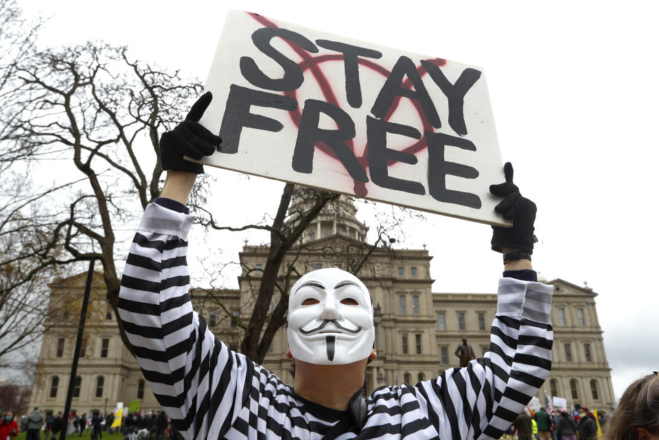 A protester holds a sign at the State Capitol in Lansing, Mich., Thursday, April 30, 2020. Hoisting American flags and handmade signs, protesters returned to the state Capitol to denounce Gov. Gretchen Whitmer's stay-home order and business restrictions due to the coronavirus pandemic while lawmakers met to consider extending her emergency declaration hours before it expires. (AP Photo/Paul Sancya)