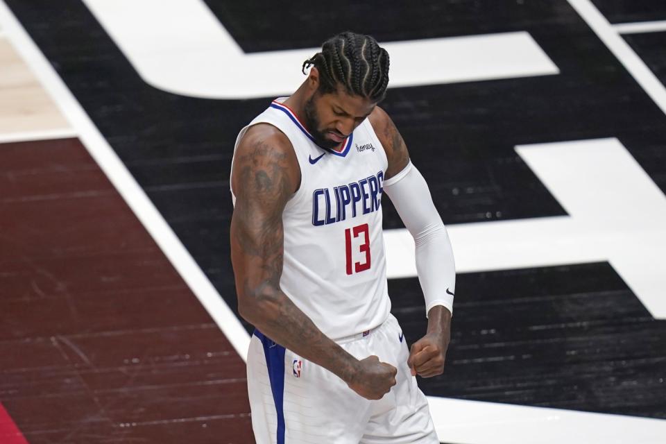 Clippers forward Paul George flexes his muscles after scoring against the Jazz.