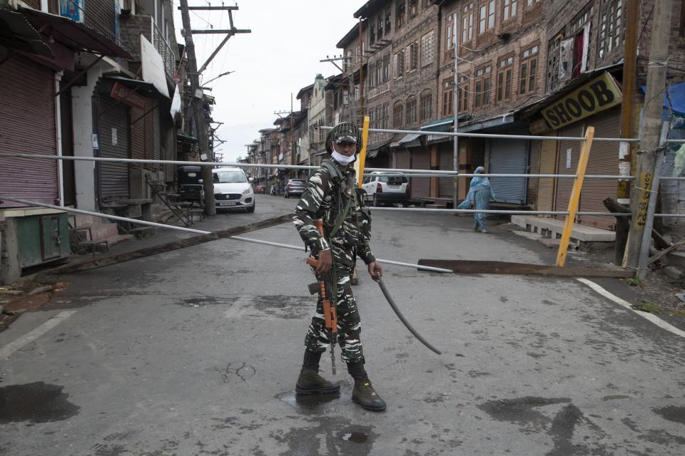 An Indian paramilitary soldier stands guard by a closed road, as Kashmiris marked Eid during lockdown to curb the spread of coronavirus in in Srinagar, Indian controlled Kashmir, Saturday, Aug. 1, 2020. (AP Photo/Mukhtar Khan)