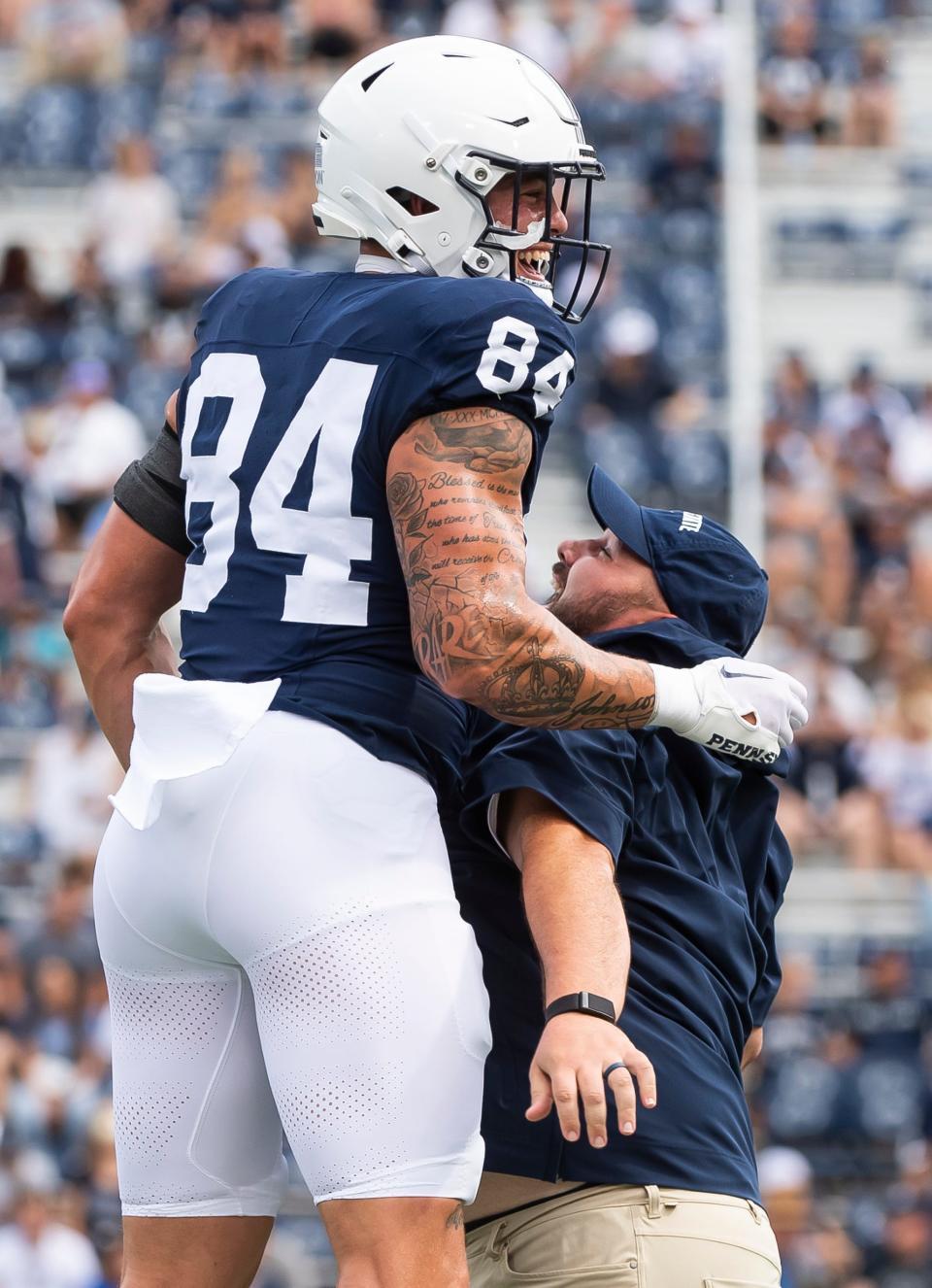 Penn State tight end Theo Johnson (84) chest bumps with Ty Howle, co-offensive coordinator/tight ends coach, before a NCAA football game against Delaware Saturday, Sept. 9, 2023, in State College, Pa.