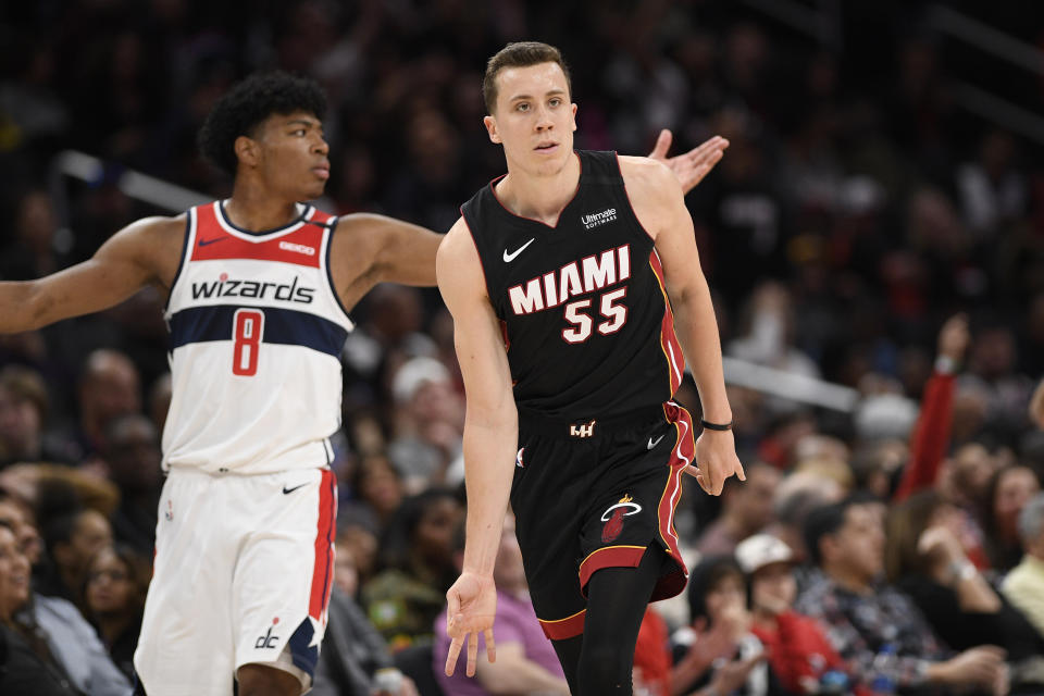 Duncan Robinson, base del Heat de Miami, festeja a un lado de Rui Hachimura, de los Wizards de Washington, tras atinar un triple en el encuentro del domingo 8 de marzo de 2020 (AP Foto/Nick Wass)