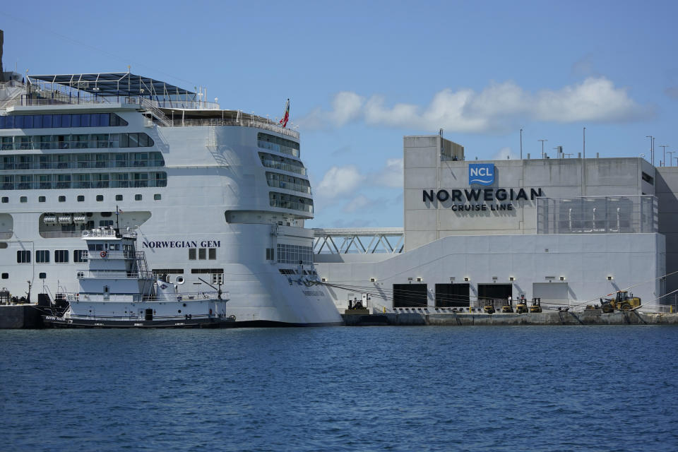 The Norwegian Gem cruise ship, left, is shown docked, Monday, Aug. 9, 2021, at PortMiami in Miami. A federal judge has temporarily blocked a Florida law that prevents cruise lines from requiring passengers to prove they're vaccinated against COVID-19. Judge Kathleen Williams says it fails to protect people even as it appears to violate the free speech rights of cruise lines. She says Norwegian Cruise Lines has shown that without proof of vaccination, cruising will jeopardize public health by potentially causing "super-spreader" events wherever passengers disembark. (AP Photo/Wilfredo Lee)