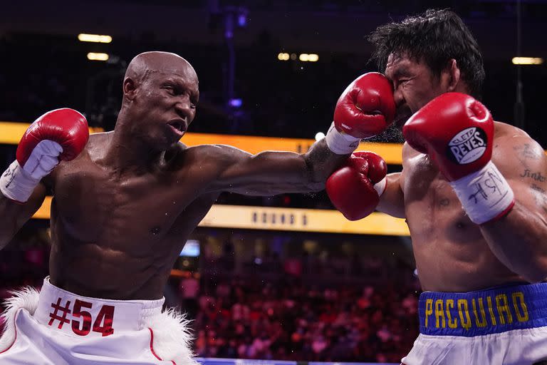 El cubano Yordenis Ugás deforma el rostro del filipino Manny Pacquiao con su mano izquierda